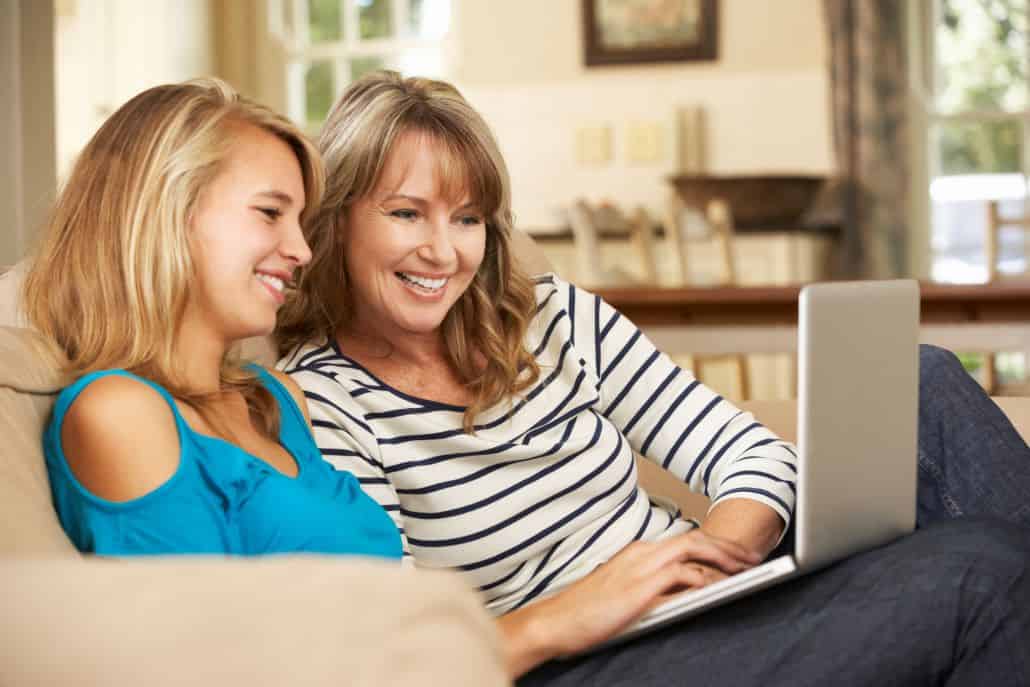 Girl and mom learning about college admissions on laptop