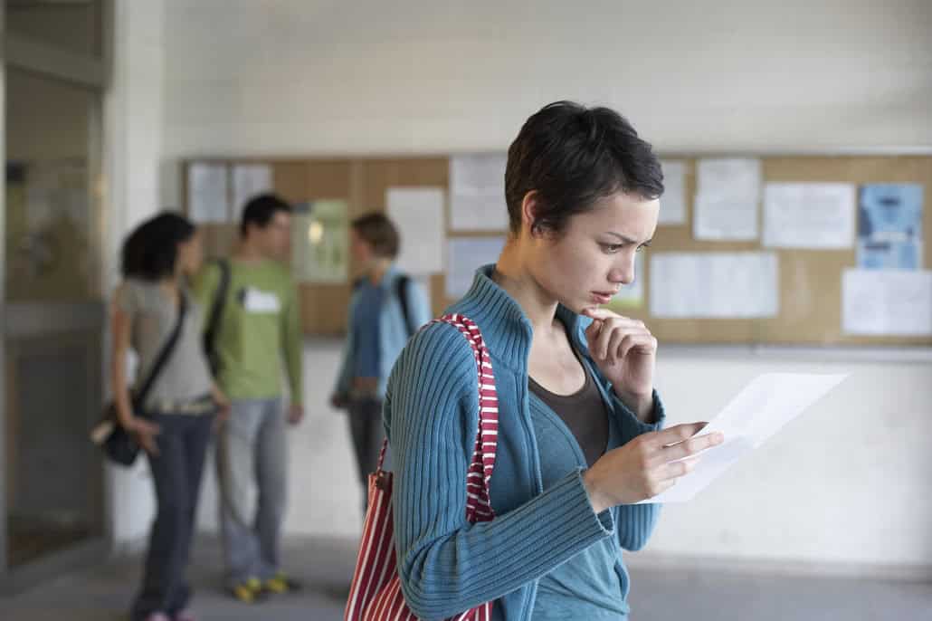 Girl looking at paper in college setting