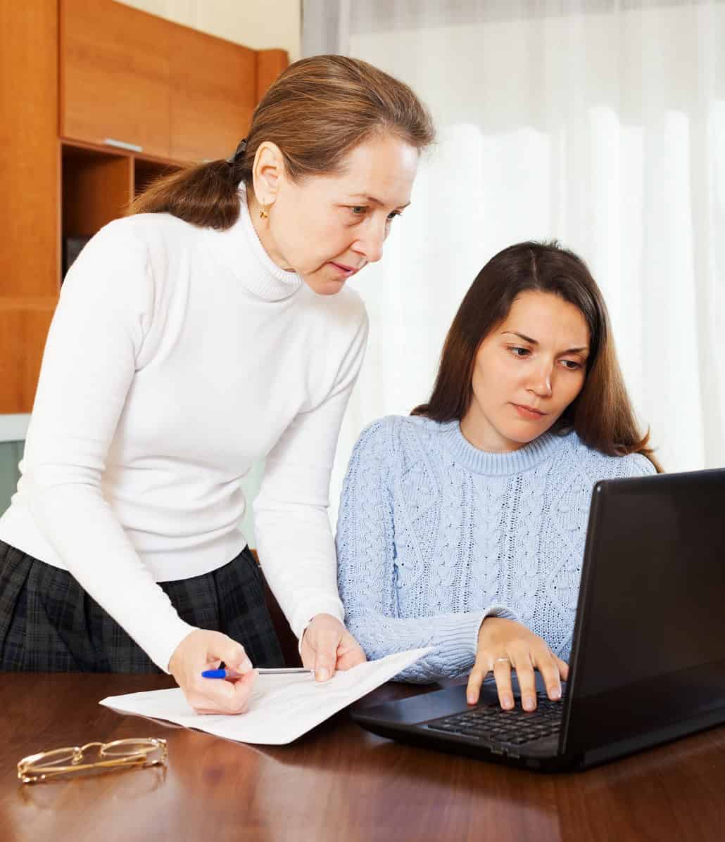 Girl working on college admissions on laptop with mom