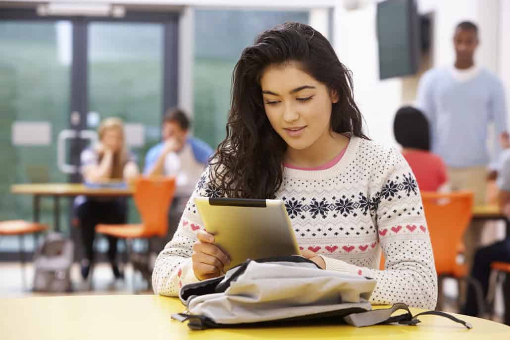 Girl reading on a tablet at school