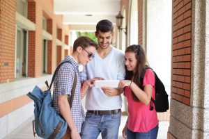 Image showing three students looking at a paper together