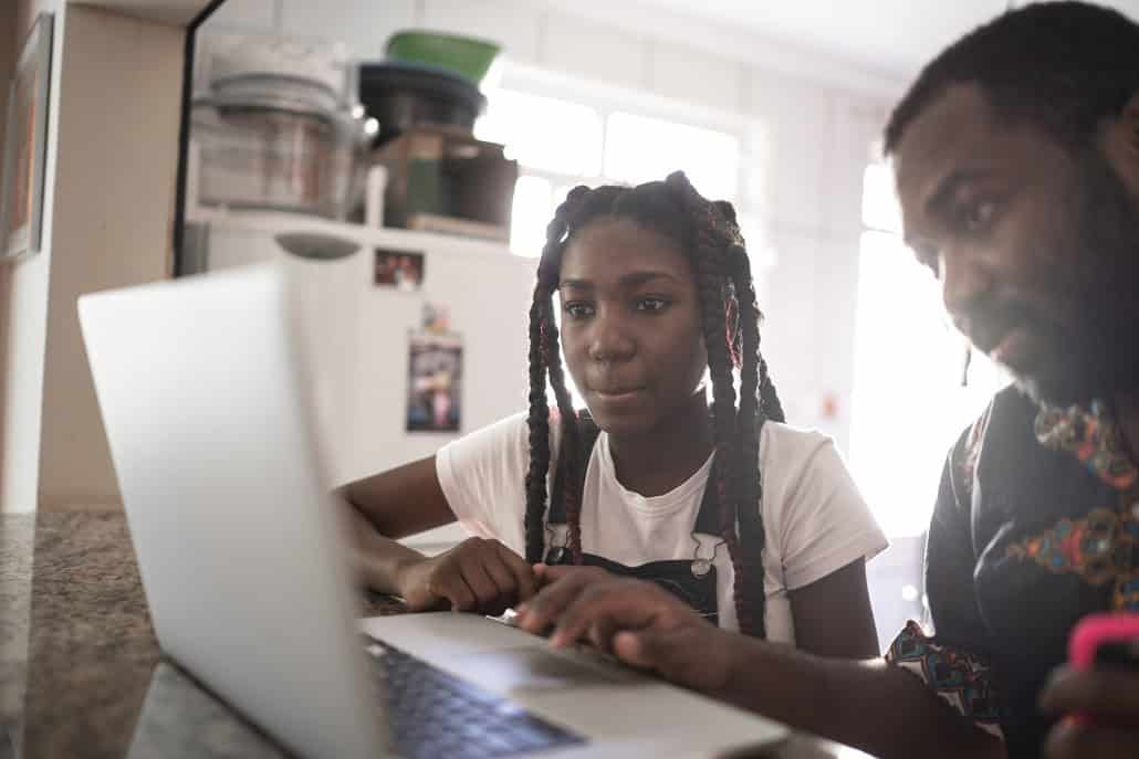 Father and daughter using laptop