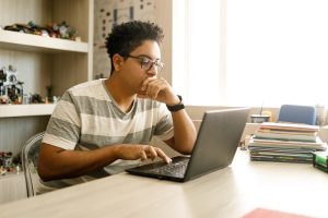 Person looking at laptop learning about grants and scholarships