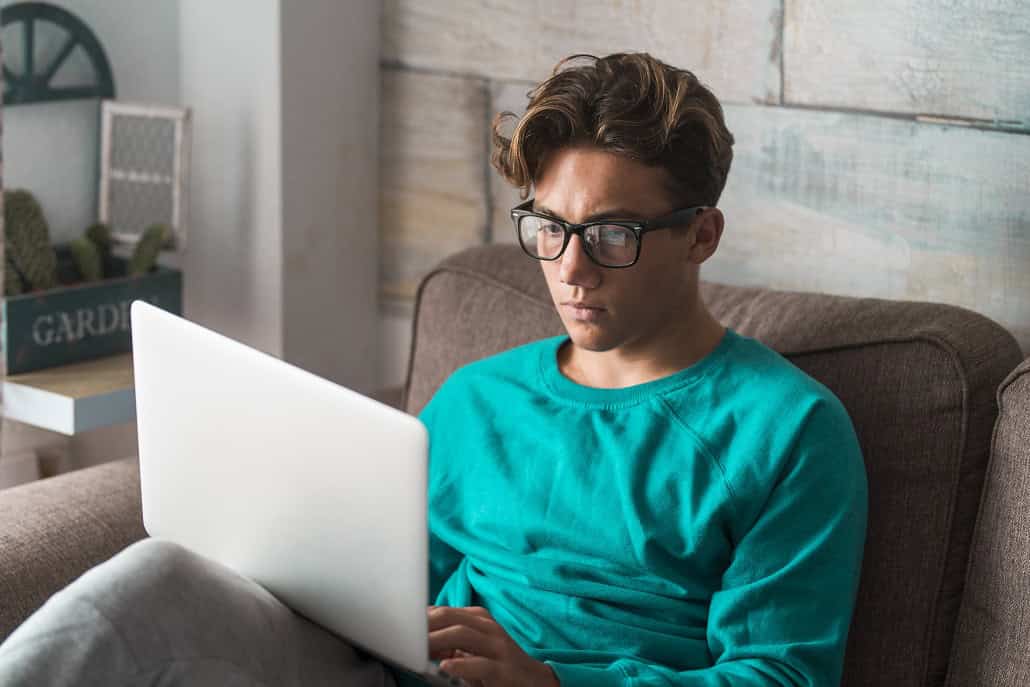 Young man reading about becoming a firefighter on a laptop