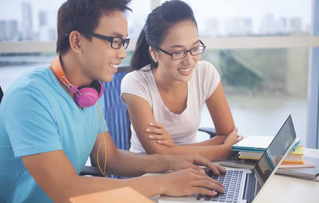 Teenage boy and girl creating a resume with MEFA Pathway on a laptop