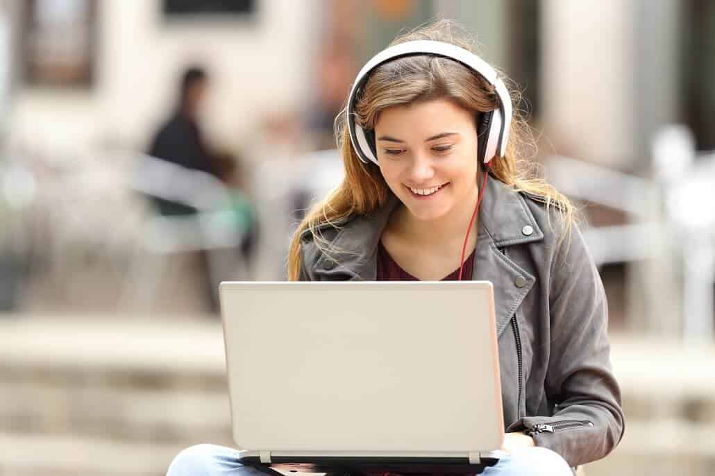 Student wearing headphones and using laptop