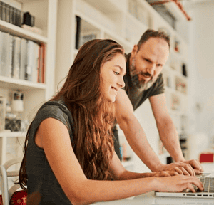 Teacher and student working on laptop