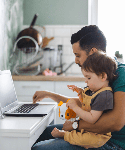 Father working on laptop with child